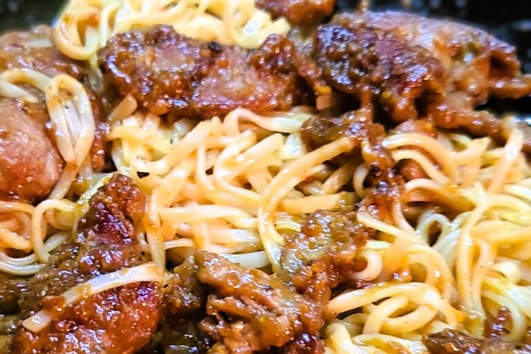 Orange beef over rice noodles.