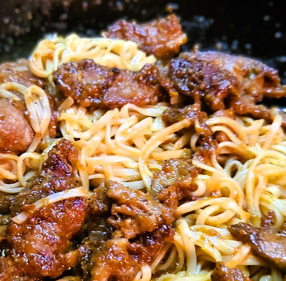 Orange beef over rice noodles.